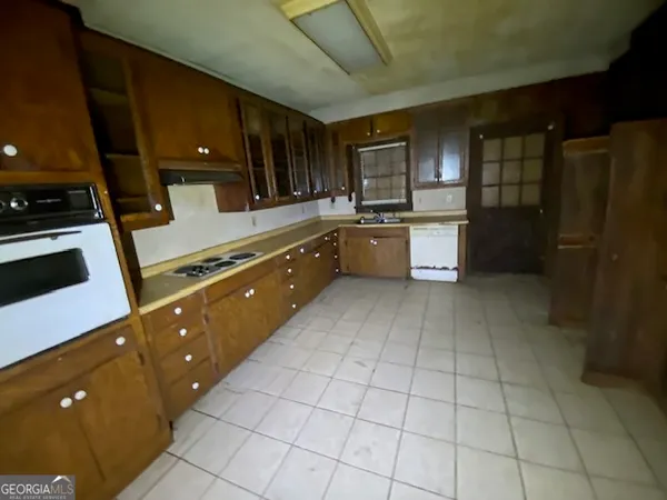 a large kitchen with a large counter top space appliances and cabinets
