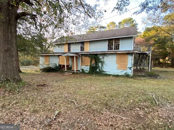 a view of a house with a yard tree and a tree