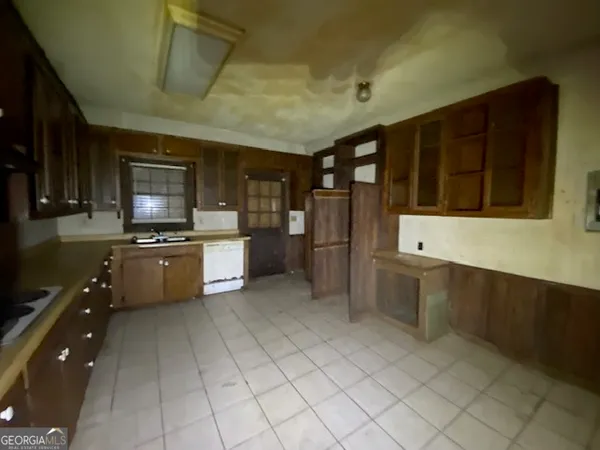 a kitchen with granite countertop a stove a sink and a refrigerator