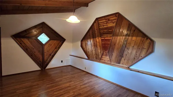 a view of a livingroom with wooden floor and a staircase