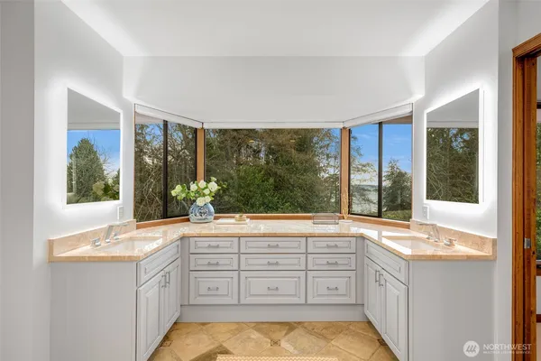 a bathroom with a granite countertop sink and a large mirror