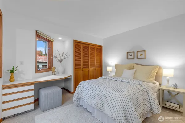 a bedroom with a bed and a large window