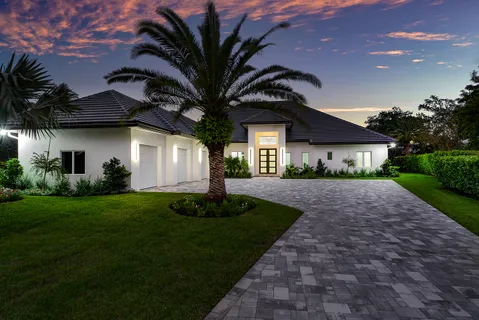 a front view of a house with a yard and potted plants