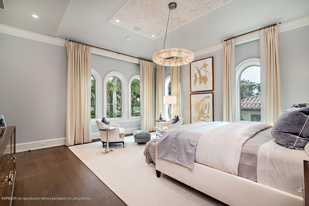 8 Golfview Road Palm Beach, FL 33480 - Photo 28 of 61 a bedroom with a large bed and a chandelier