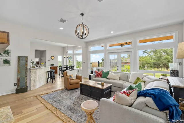 a living room with furniture wooden floor and a large window
