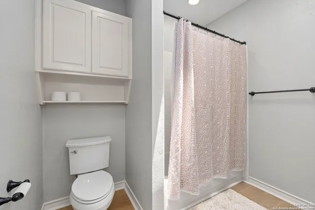 a white toilet sitting next to a shower