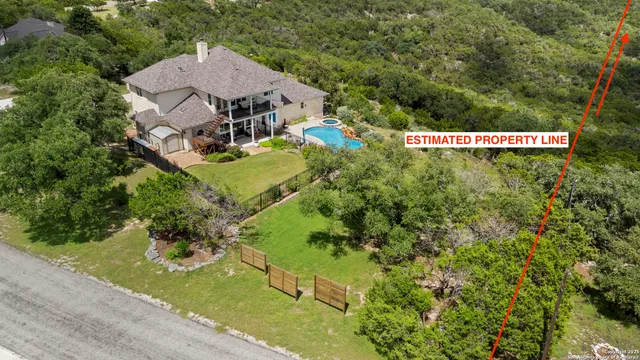 an aerial view of residential houses with outdoor space and trees