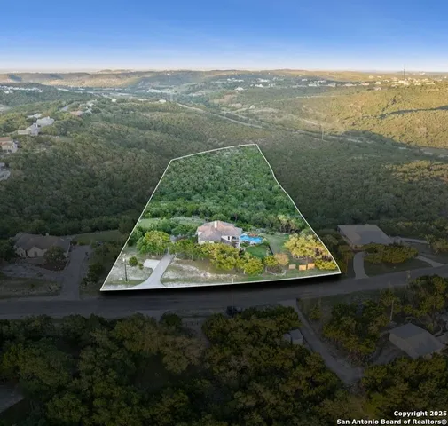 a view of a wooden house with a tree and a park