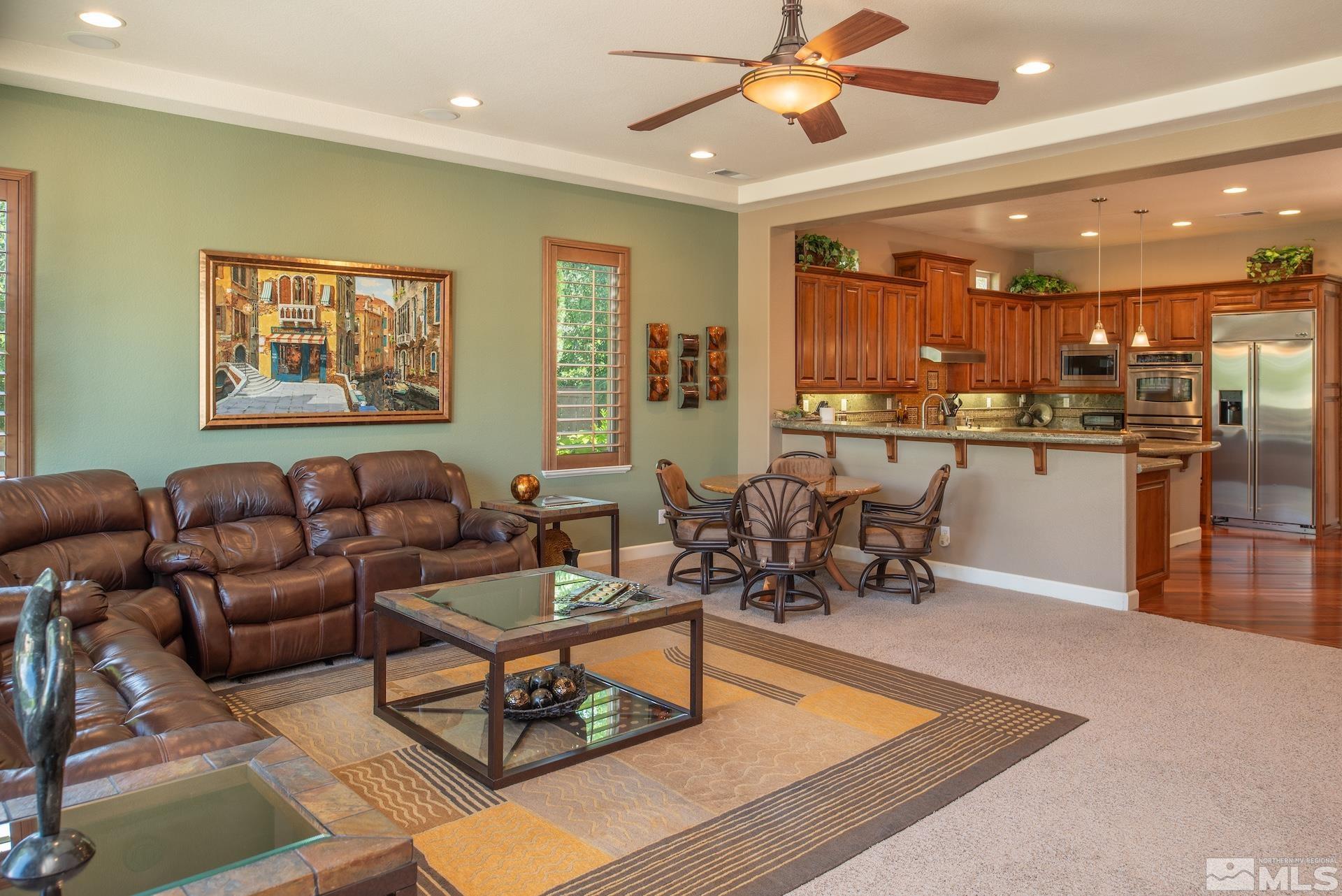 2635 Vitoria Lane Reno, NV 89521 - Photo 6 of 40 a living room with stainless steel appliances kitchen island granite countertop furniture and a wooden floor