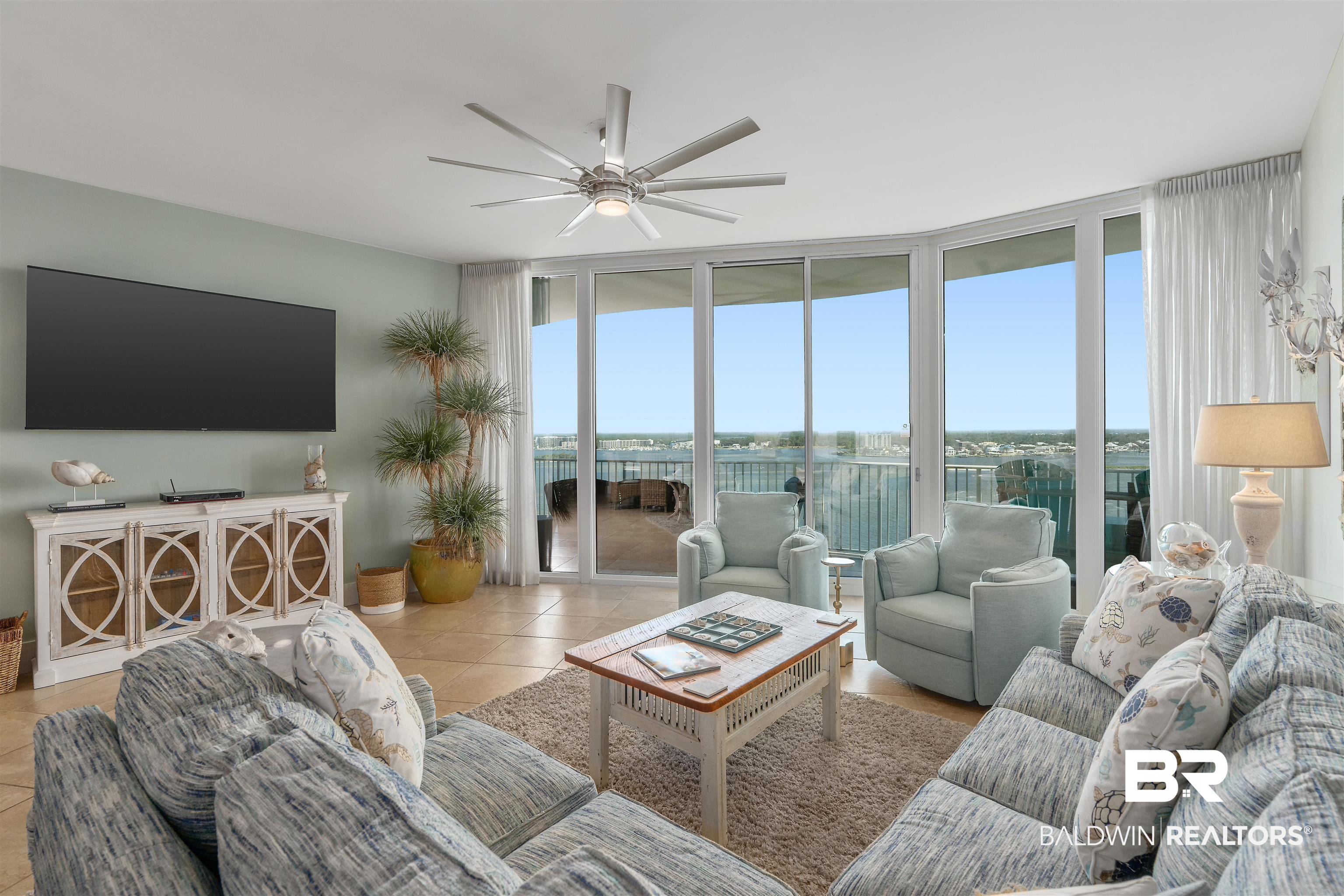 28107 Perdido Beach Boulevard, Unit DPH06 Orange Beach, AL 36561 - Photo 9 of 70 Living room with ceiling fan, light tile patterned floors, floor to ceiling windows, and a water view