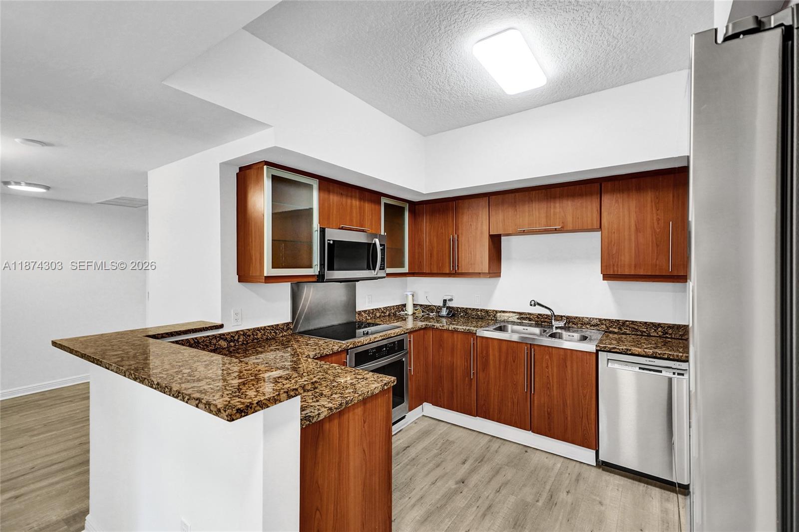888 Douglas Road, Unit 304 Coral Gables, FL 33134 - Photo 13 of 52 a kitchen with stainless steel appliances granite countertop a sink stove and cabinets