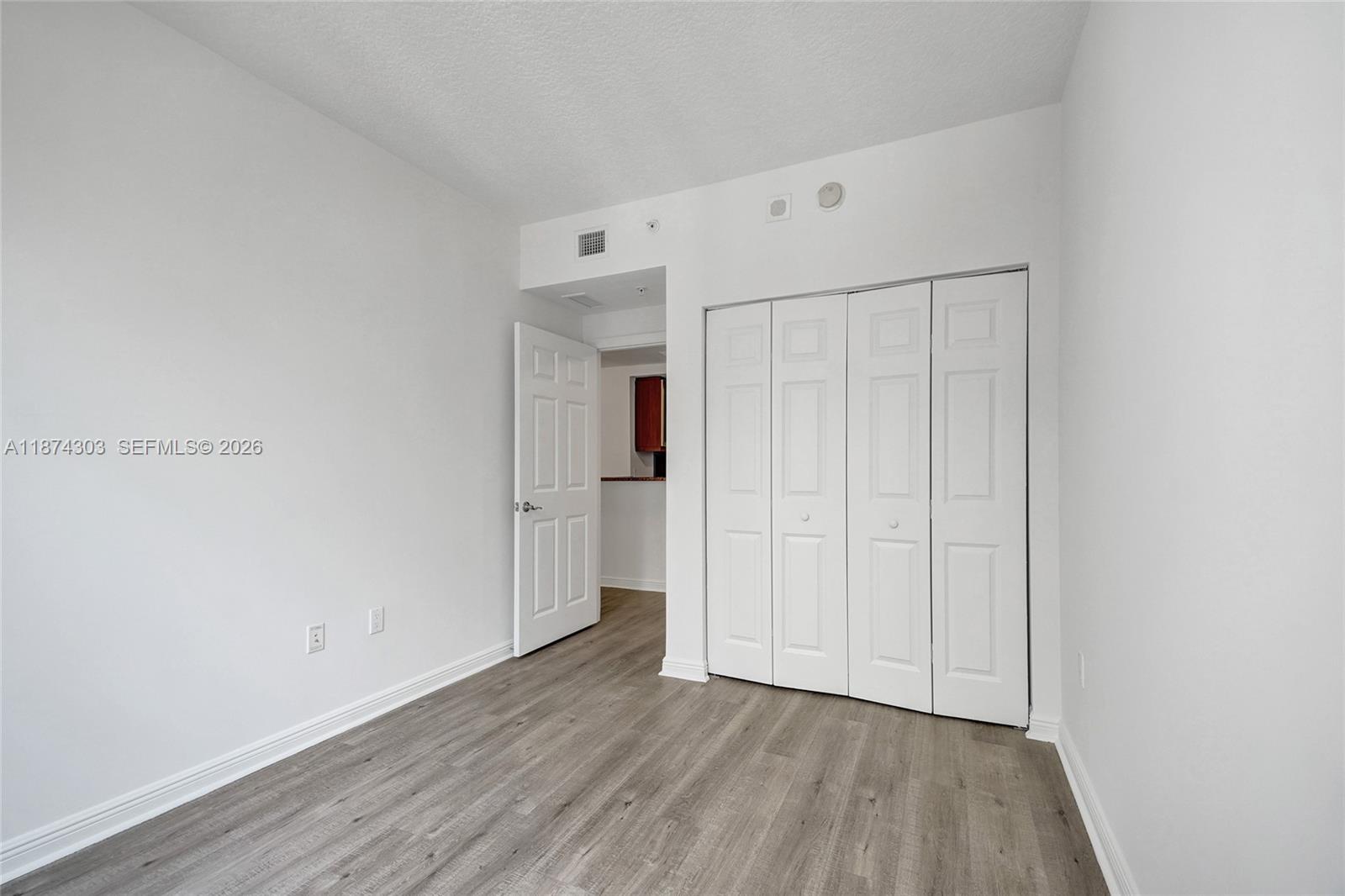 888 Douglas Road, Unit 304 Coral Gables, FL 33134 - Photo 18 of 52 a view of an empty room with wooden floor
