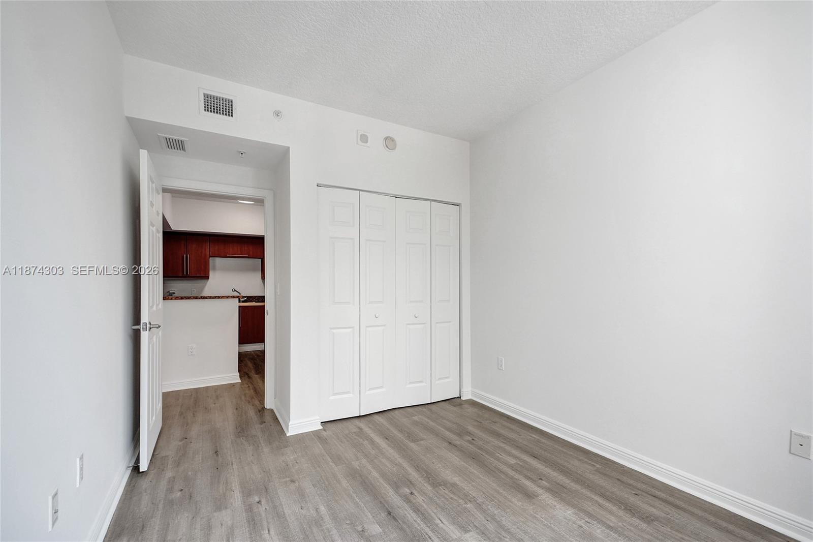 888 Douglas Road, Unit 304 Coral Gables, FL 33134 - Photo 19 of 52 a view of a hallway with wooden floor and closet