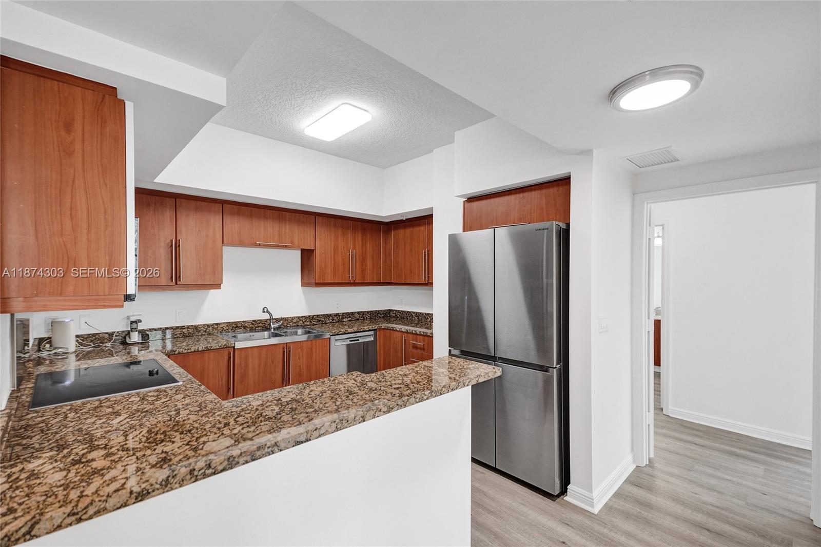 888 Douglas Road, Unit 304 Coral Gables, FL 33134 - Photo 2 of 52 a kitchen with stainless steel appliances granite countertop a refrigerator and a sink