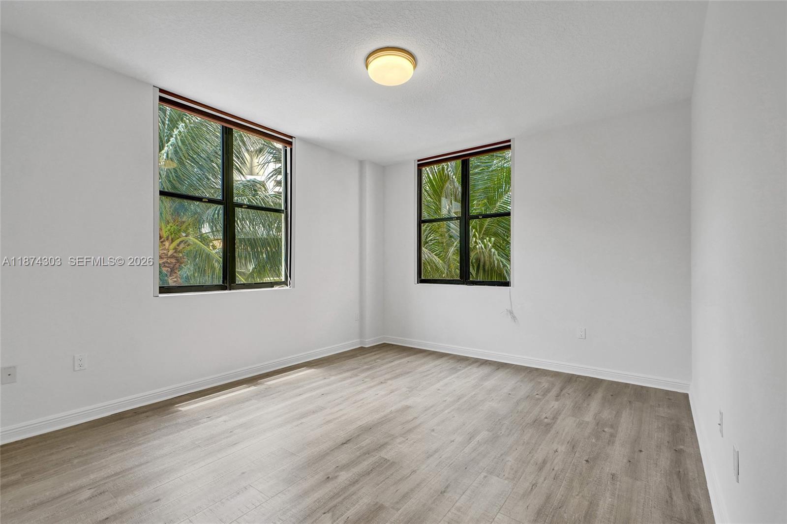 888 Douglas Road, Unit 304 Coral Gables, FL 33134 - Photo 21 of 52 wooden floor in an empty room with a window