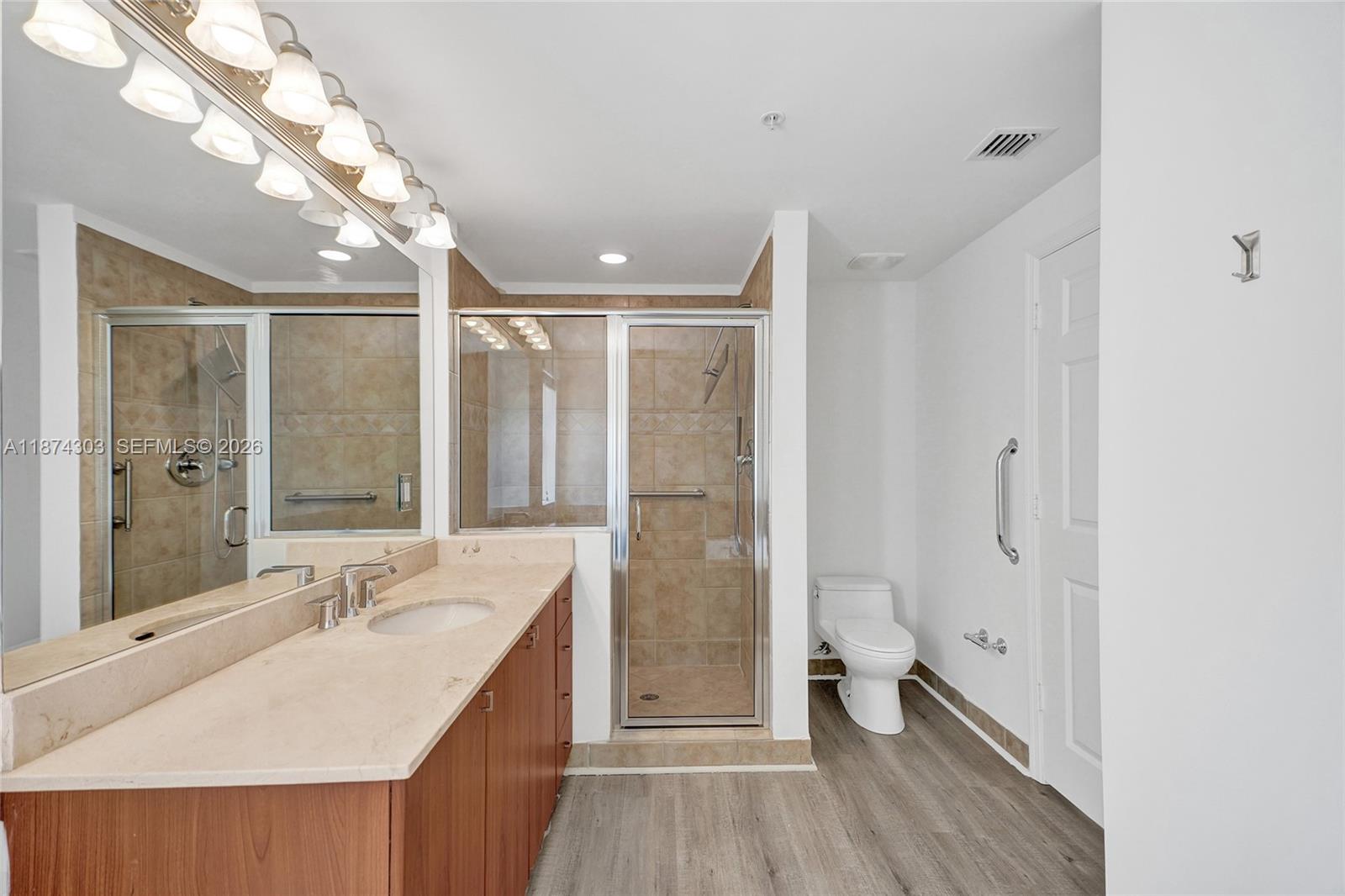 888 Douglas Road, Unit 304 Coral Gables, FL 33134 - Photo 26 of 52 a bathroom with a double vanity sink a large mirror a shower and a bathtub