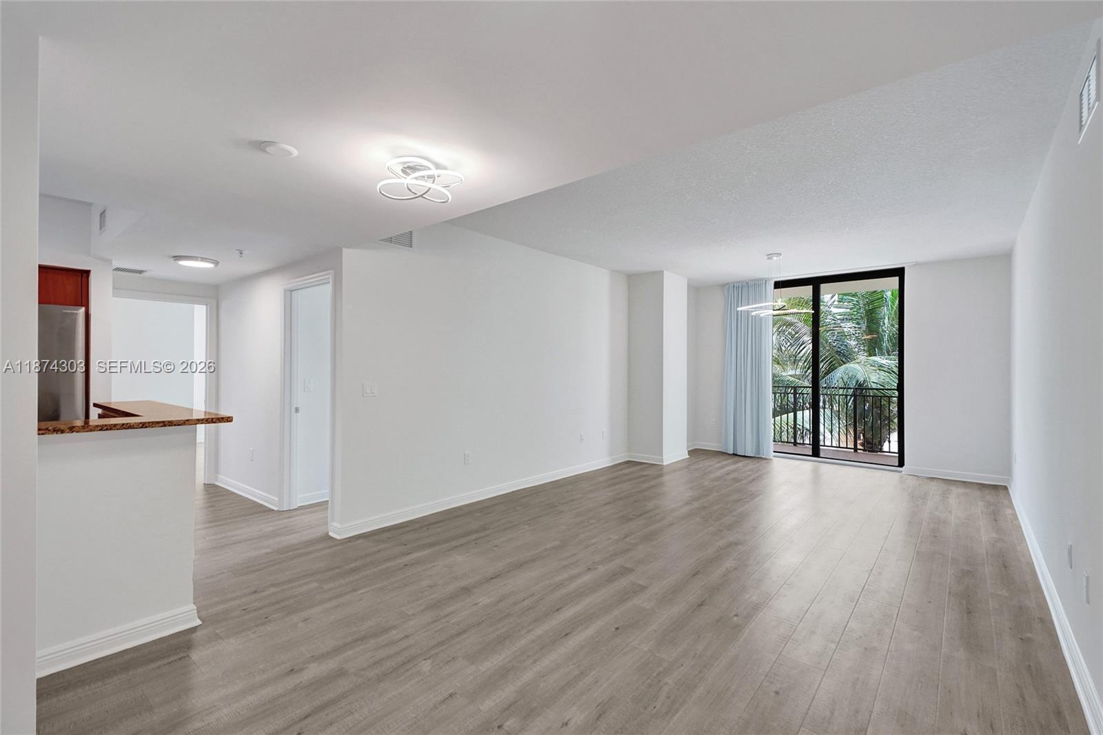 888 Douglas Road, Unit 304 Coral Gables, FL 33134 - Photo 5 of 52 a view of an empty room with wooden floor and a window