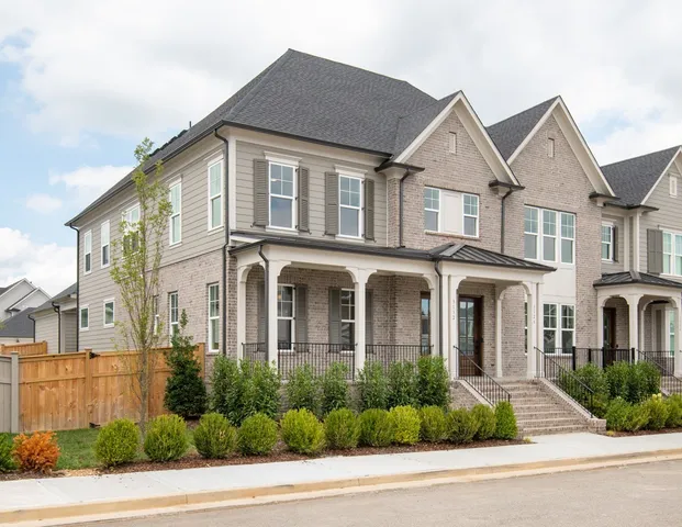 a view of a white house with a yard and plants