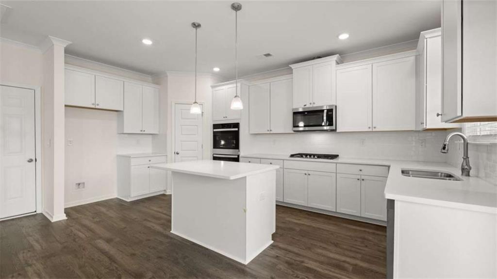1791 Goodwin Drive Hampton, GA 30228 - Photo 11 of 43 a kitchen with kitchen island a sink a stove a refrigerator and white cabinets