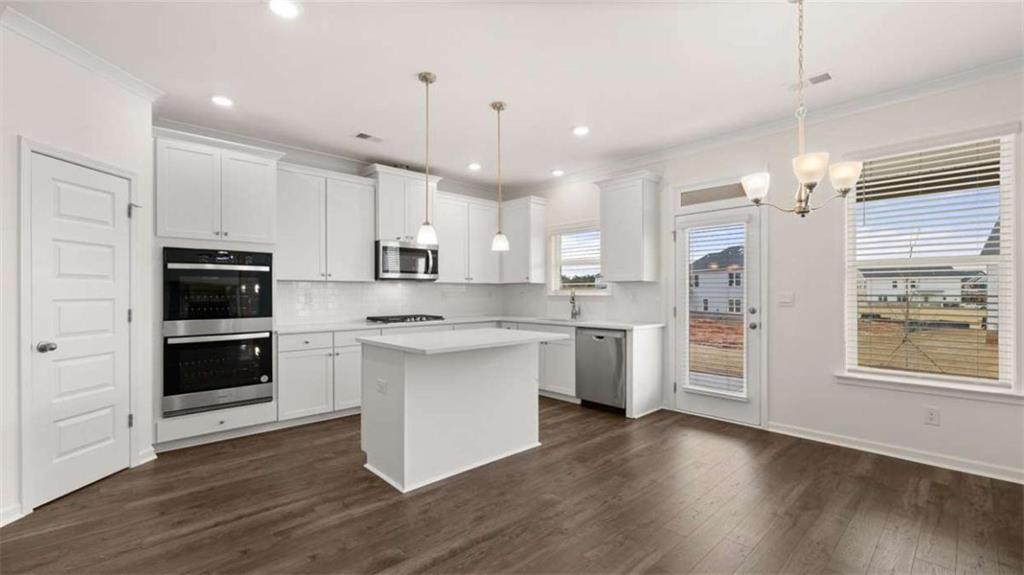 1791 Goodwin Drive Hampton, GA 30228 - Photo 9 of 43 a kitchen with stainless steel appliances white cabinets a sink a stove a refrigerator and white cabinets