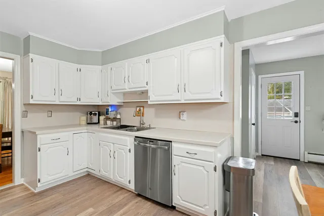 a kitchen with white cabinets and sink