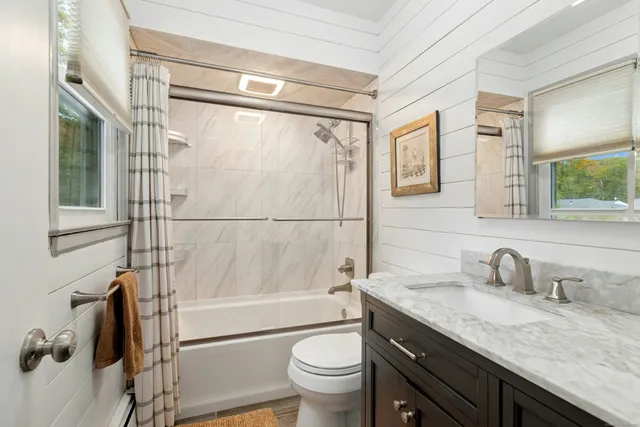 a bathroom with a granite countertop sink toilet and shower