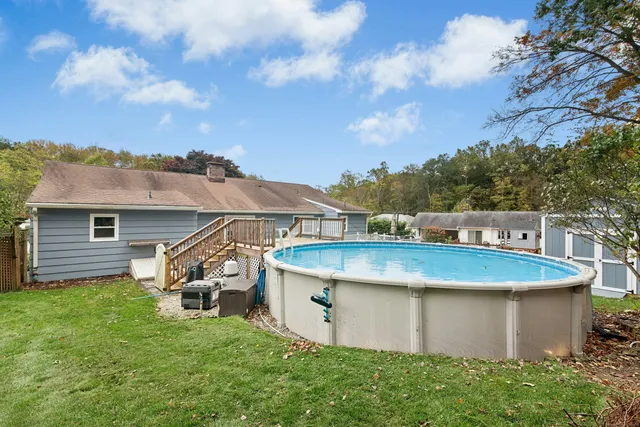 a view of a white house with a sink and a yard