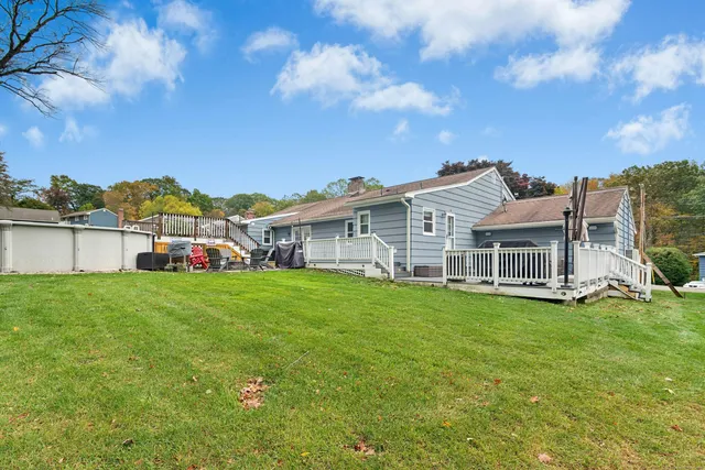 a view of a house with a big yard and large trees