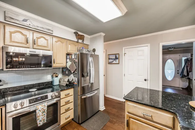a kitchen with granite countertop a stove and a refrigerator