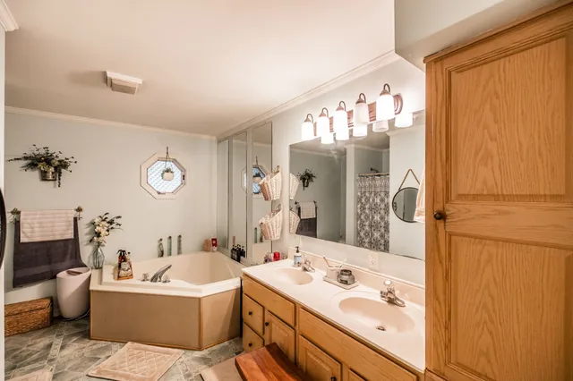 a bathroom with a tub sink and mirror