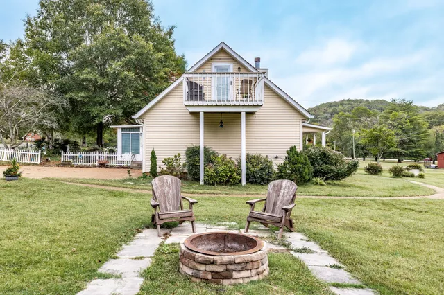 a view of a big yard with a house and a large tree