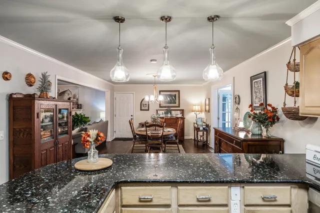 a kitchen with stainless steel appliances granite countertop a stove a refrigerator and a dining table