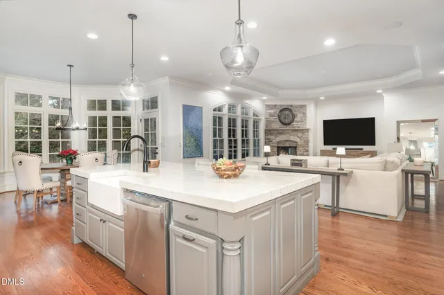 a large kitchen with kitchen island granite countertop a stove and a view of living room