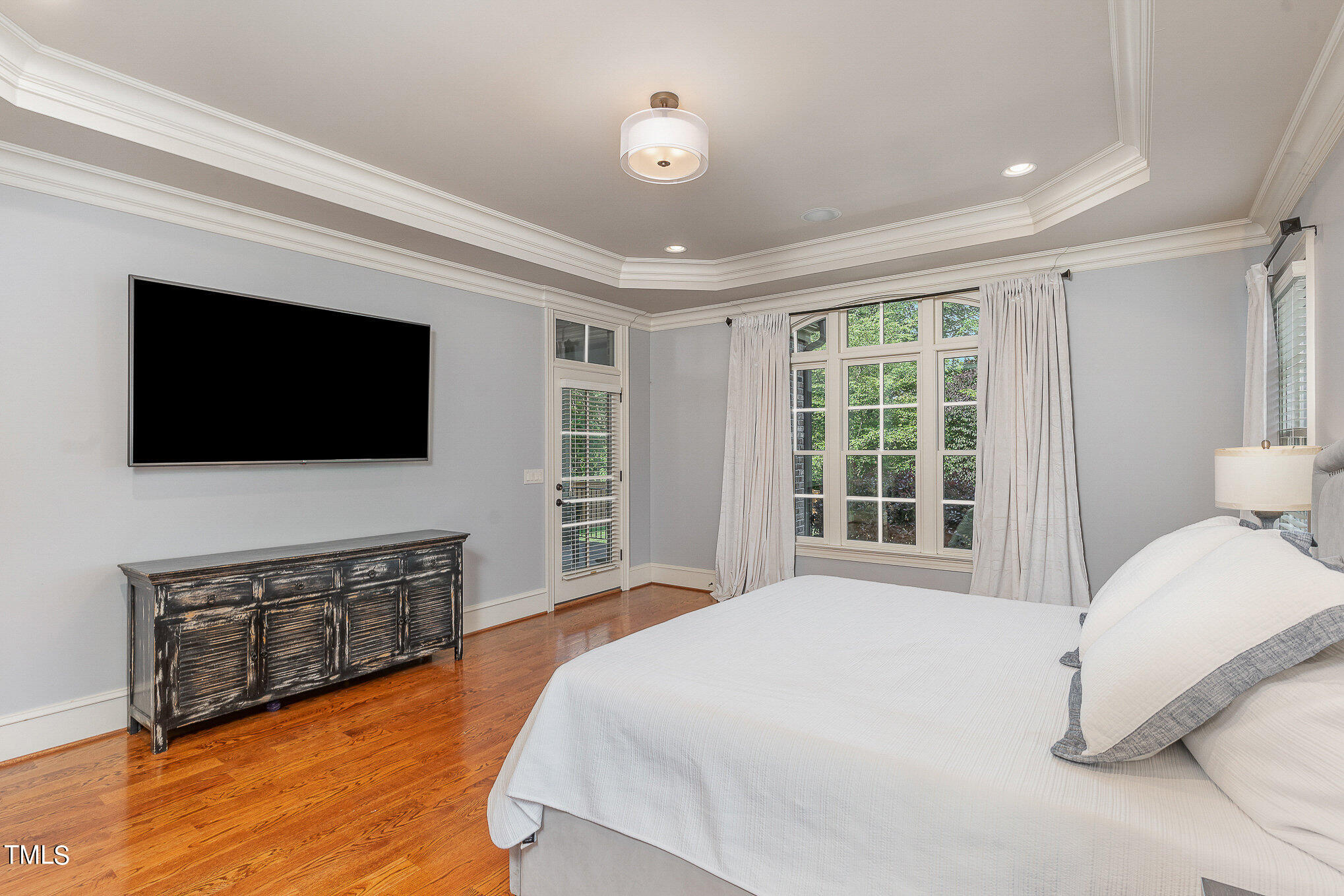 2908 Claremont Road Raleigh, NC 27608 - Photo 22 of 46 a spacious bedroom with a bed and a flat screen tv