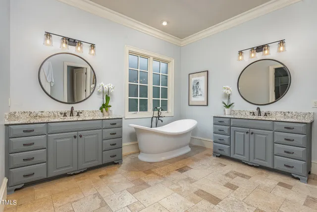 a bathroom with a granite countertop double vanity sink and a mirror
