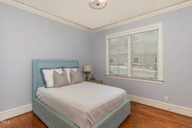 a large bed sitting in a bedroom next to a window