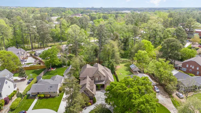 an aerial view of residential houses with outdoor space and trees