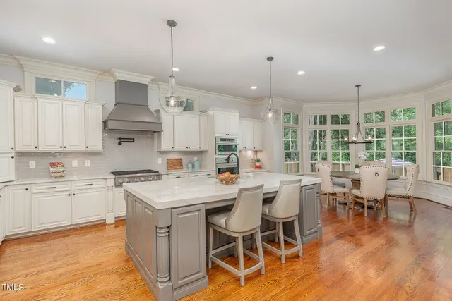 a large kitchen with kitchen island a island a sink a stove and a center island