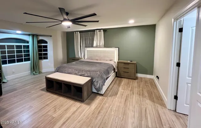 a spacious bedroom with a bed and wooden floor