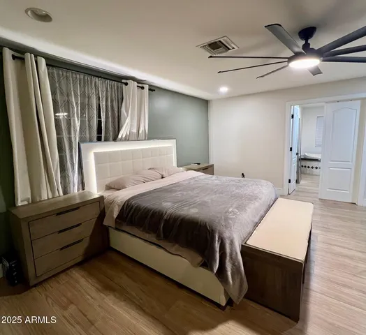 a spacious bedroom with a bed and a chandelier