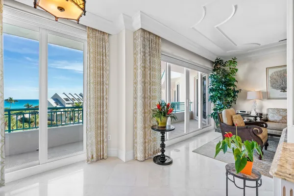 a living room with furniture a large window and wooden floor