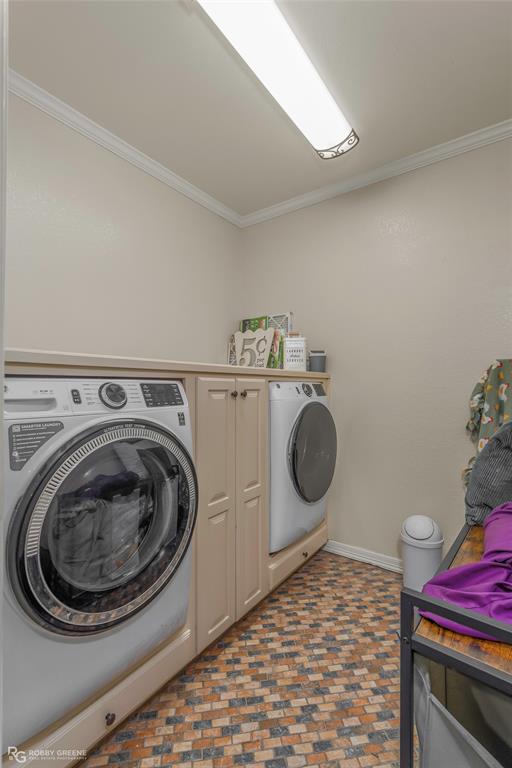 624 Holly Street Grand Cane, LA 71032 - Photo 20 of 40 Laundry area featuring washing machine and clothes dryer, ornamental molding, brick flooring, and cabinet space