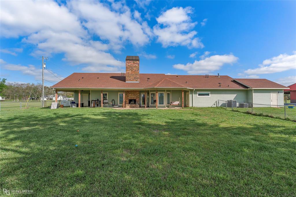 624 Holly Street Grand Cane, LA 71032 - Photo 33 of 40 Back of property with a patio, a fenced backyard, a chimney, and a fireplace