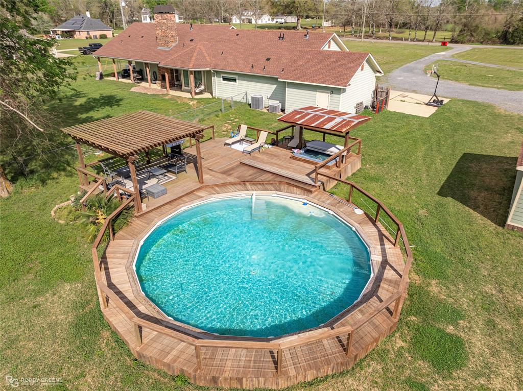 624 Holly Street Grand Cane, LA 71032 - Photo 38 of 40 View of pool with a yard, a deck, patio surround, and view of wooded area