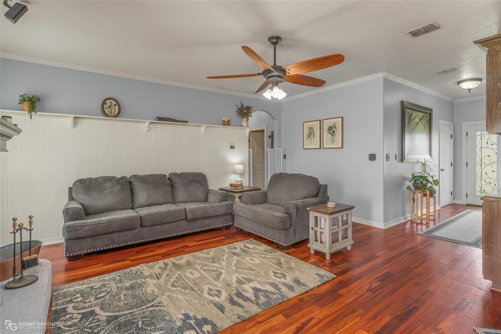 624 Holly Street Grand Cane, LA 71032 - Photo 4 of 40 Living area with crown molding, dark wood-type flooring, ceiling fan, and arched walkways