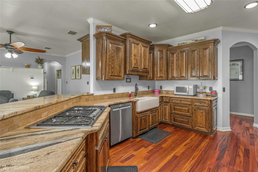 624 Holly Street Grand Cane, LA 71032 - Photo 6 of 40 Kitchen with arched walkways, ornamental molding, light stone counters, a ceiling fan, and stainless steel appliances