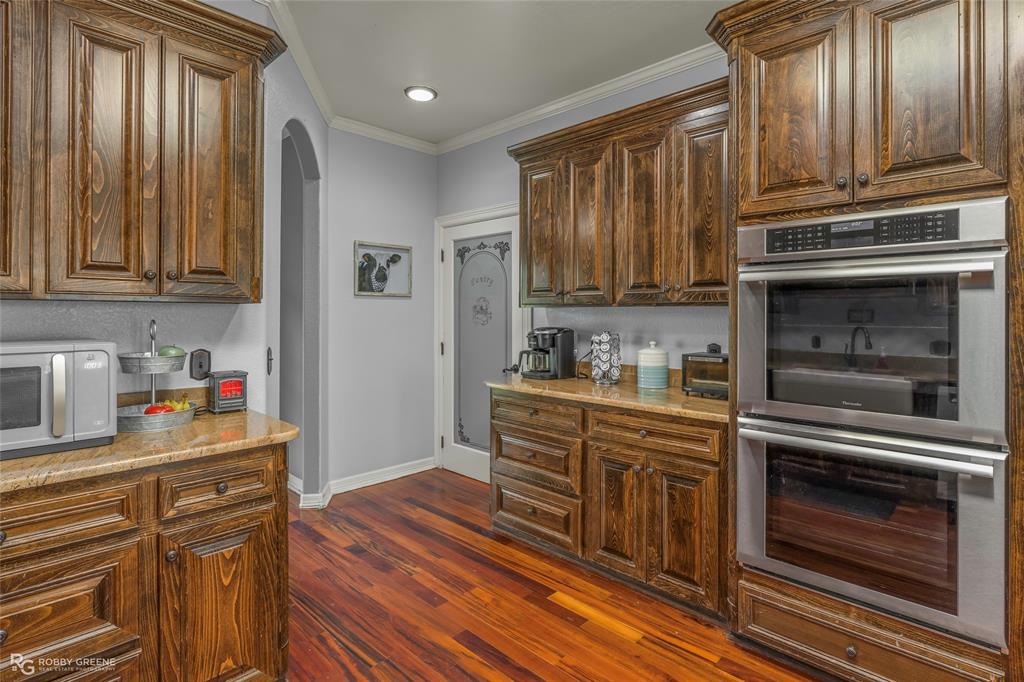 624 Holly Street Grand Cane, LA 71032 - Photo 7 of 40 Kitchen with stainless steel appliances, arched walkways, ornamental molding, and dark wood-type flooring