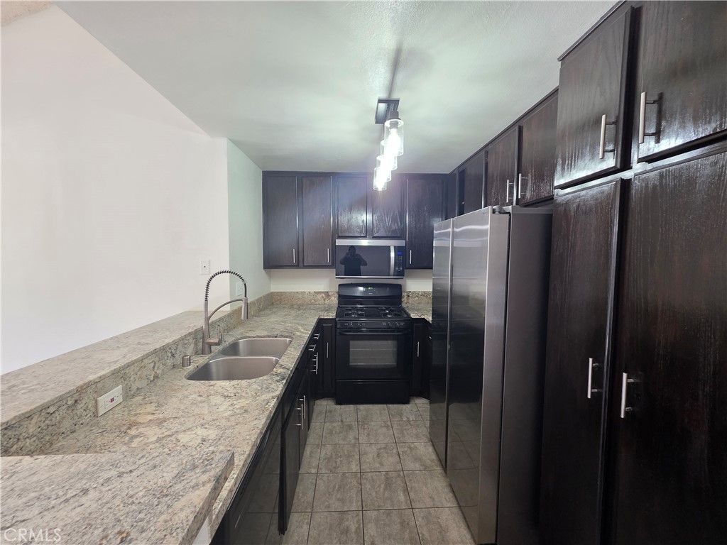 14839 Sherman Way, Unit 6 Van Nuys, CA 91405 - Photo 6 of 23 a kitchen with granite countertop a refrigerator and a sink