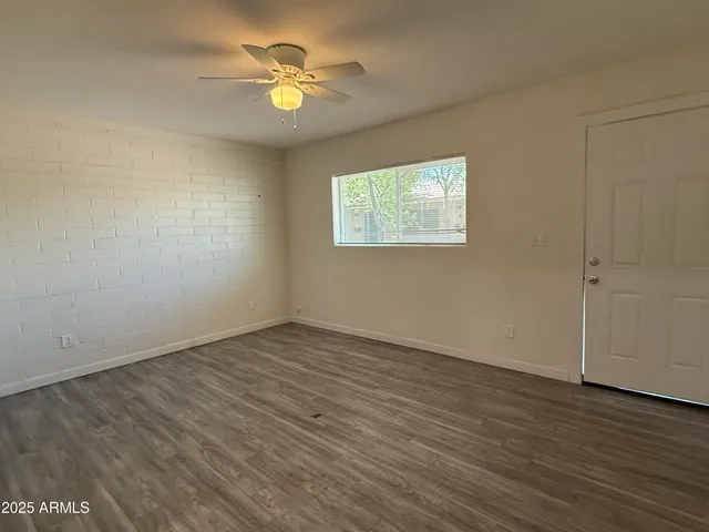 an empty room with wooden floor and window