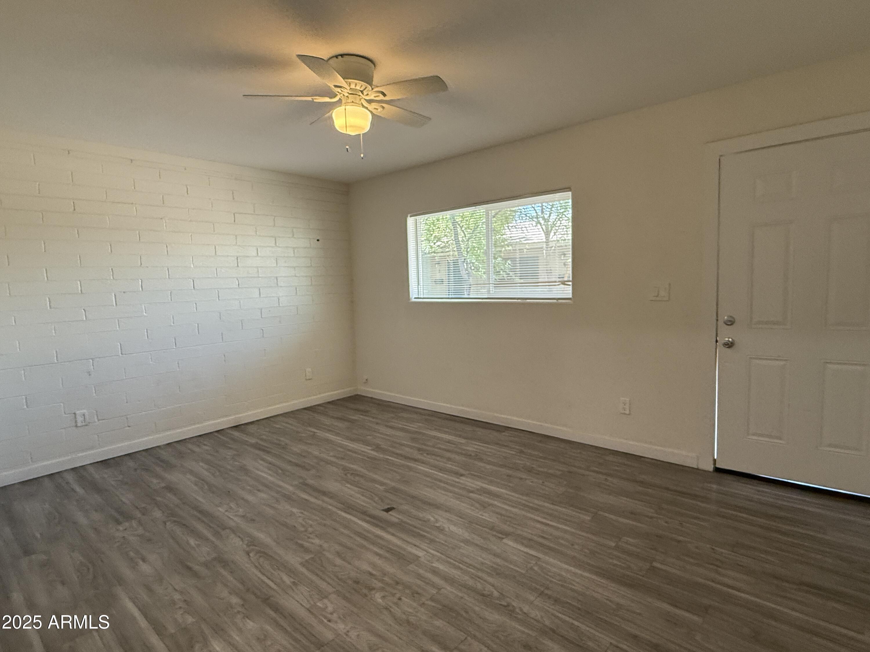 1625 West Fillmore Street, Unit 1 Phoenix, AZ 85007 - Photo 5 of 10 an empty room with wooden floor and window